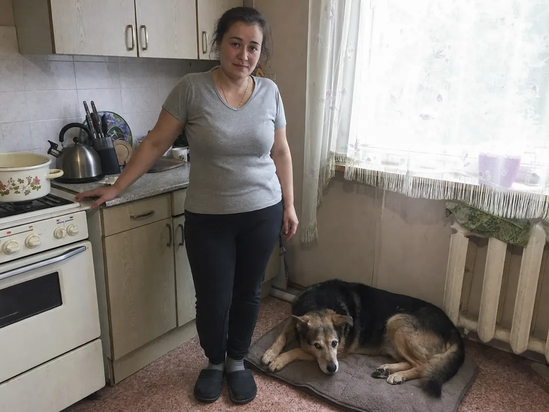 Владелица с крупной пожилой собакой на кухне