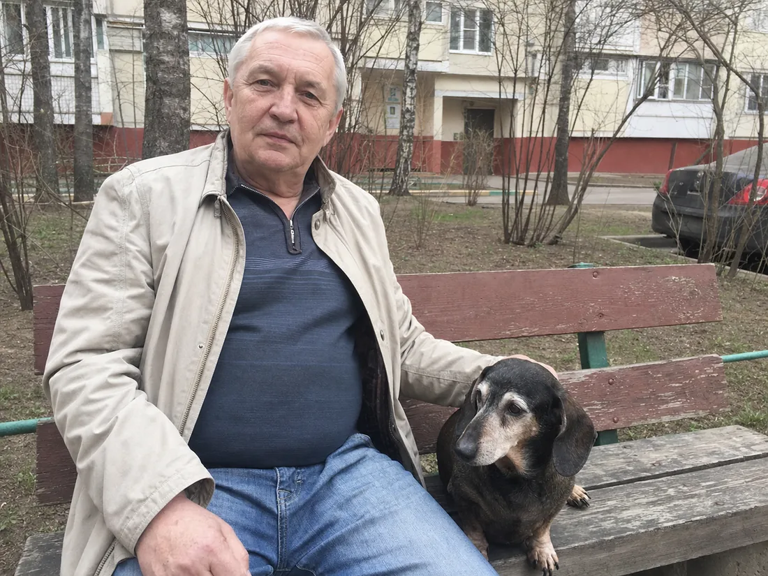 Владелец с пожилой таксой во дворе